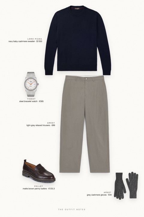 Flat-lay of the pieces in this outfit: navy baby cashmere sweater, light-grey relaxed trousers, matte brown penny loafers, steel bracelet watch, grey cashmere gloves.