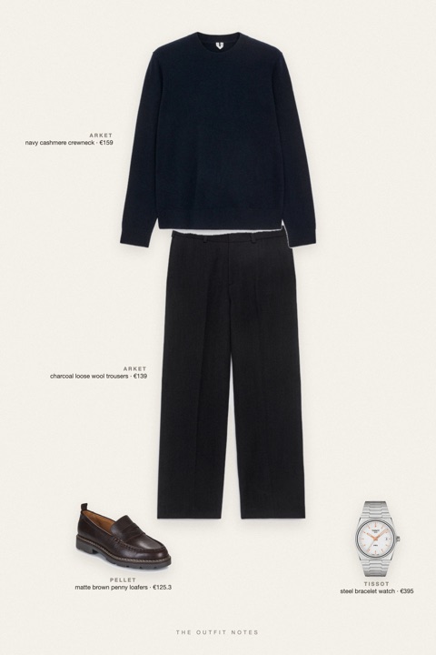 Flat-lay of the pieces in this outfit: navy cashmere crewneck, charcoal loose wool trousers, matte brown penny loafers, steel bracelet watch.