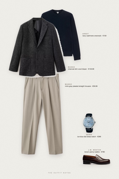 Flat-lay of the pieces in this outfit: charcoal slim wool blazer, navy cashmere crewneck, mink-grey pleated straight trousers, brown penny loafers, ice-blue dial dress watch.